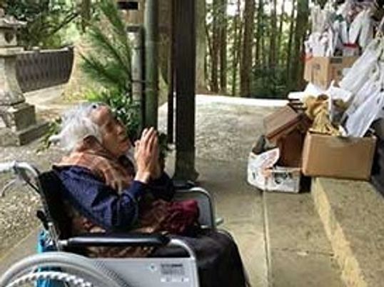 車椅子の高齢者と祭壇