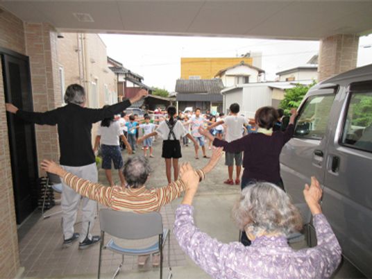 笑顔で体操する人々の居室