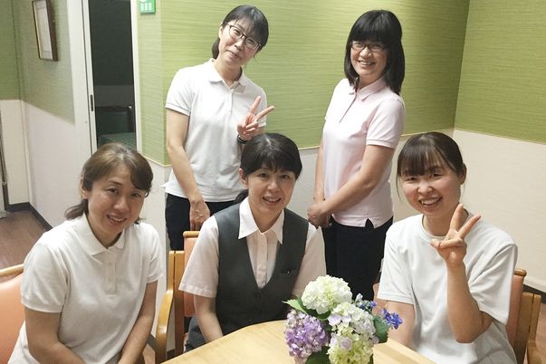 笑顔のスタッフと花のテーブル