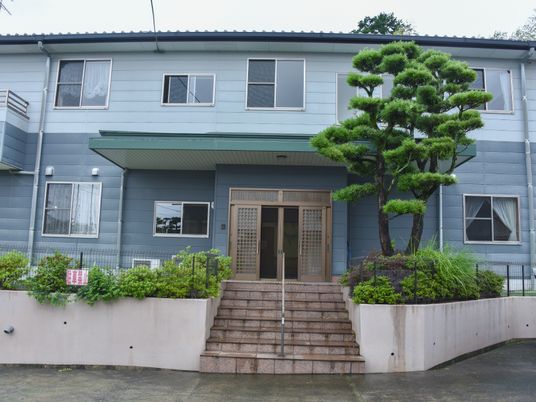 緑樹に囲まれた建物入口