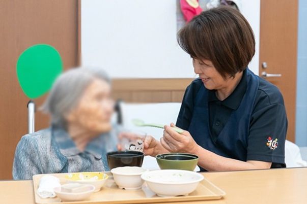 笑顔で食事補助をする様子