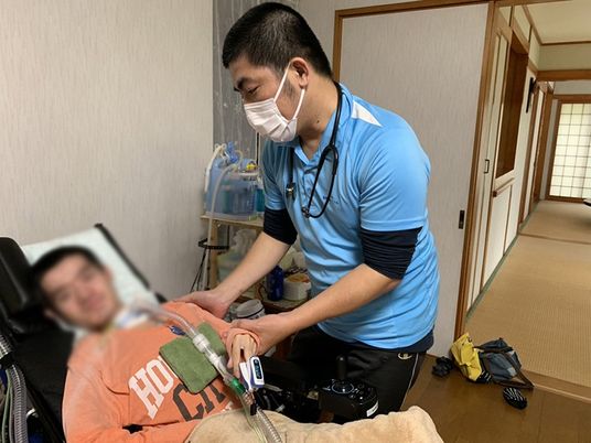 介護中のスタッフと患者の居室
