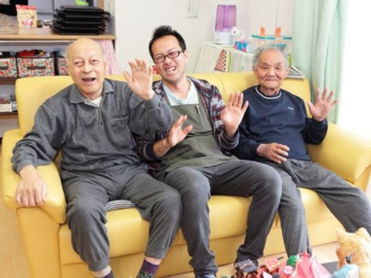 笑顔で挨拶する利用者と職員