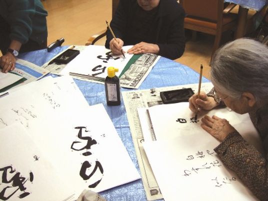 書道をする高齢者グループ