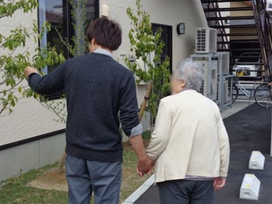 手をつなぐ二人と外壁