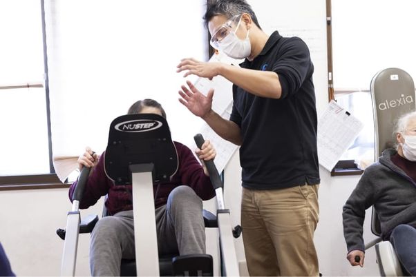 人々が運動器具を使用中の機能訓練室