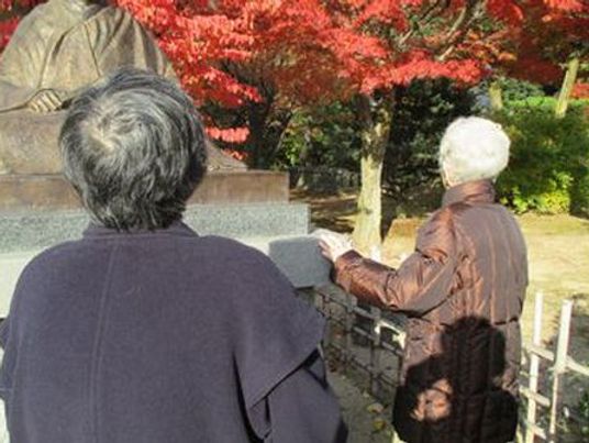 紅葉と像を見る人々