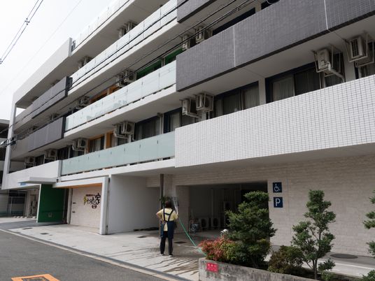 建物の外観と掃除中の人