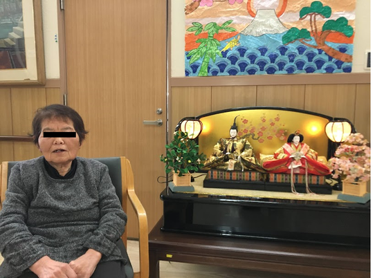 人形と座る女性の室内
