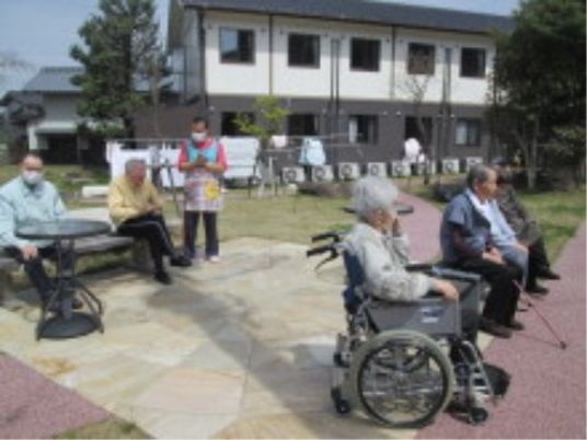 屋外で憩う利用者とスタッフ