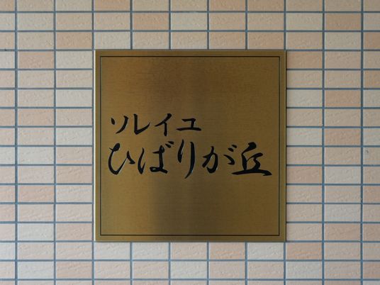 ゴールドの看板とタイル壁