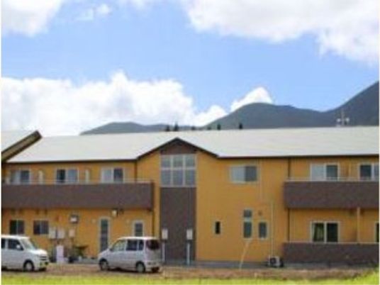 山並み背景の黄色い建物