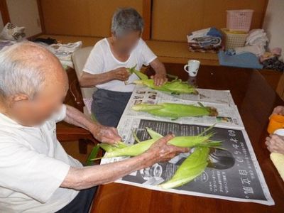 笑顔でとうもろこしをむく人々