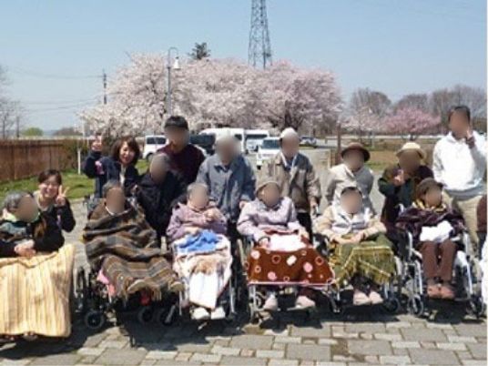 桜と利用者の集合写真