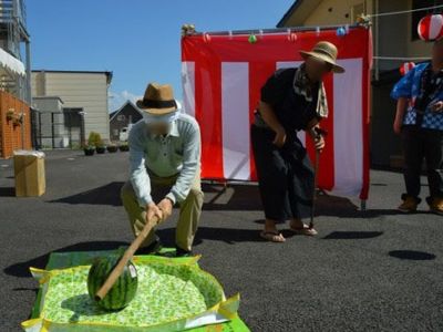 屋外でスイカ割りをする人々