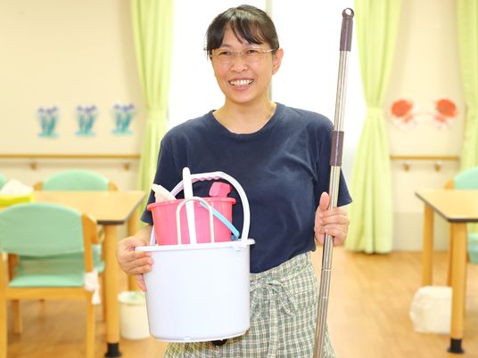 笑顔のスタッフと清掃用具