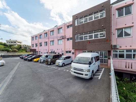 ピンクの建物と駐車場