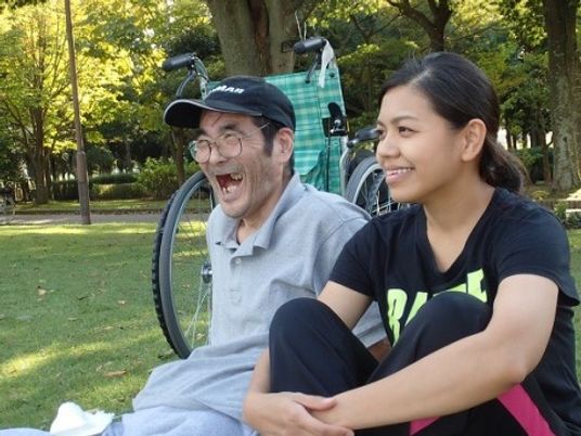 笑顔で座る二人と車椅子