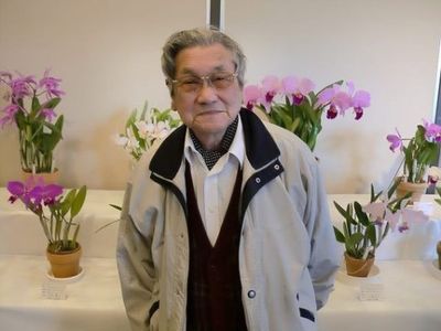 花と共に立つ笑顔のおじいさん