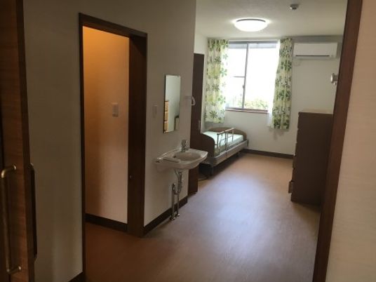 居室の洗面所とベッド