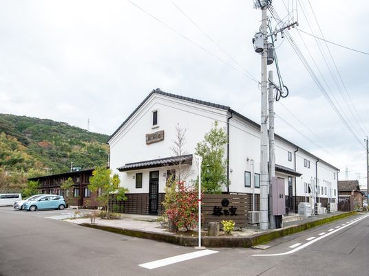 白壁の建物と緑の山並み