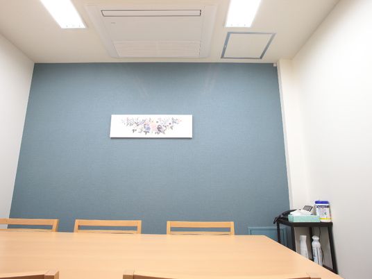 青壁とテーブルの会議室