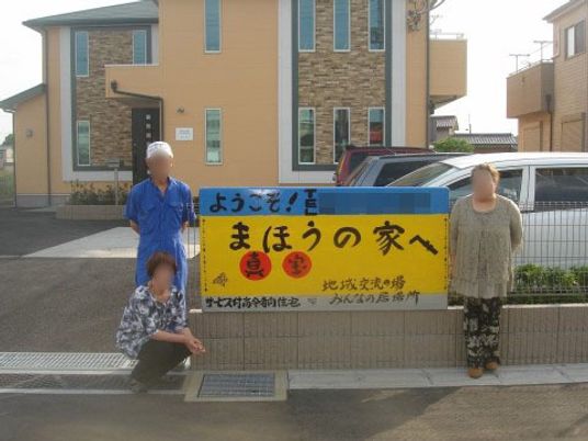 施設前の人々と看板