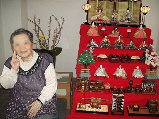 女性と雛人形の飾り
