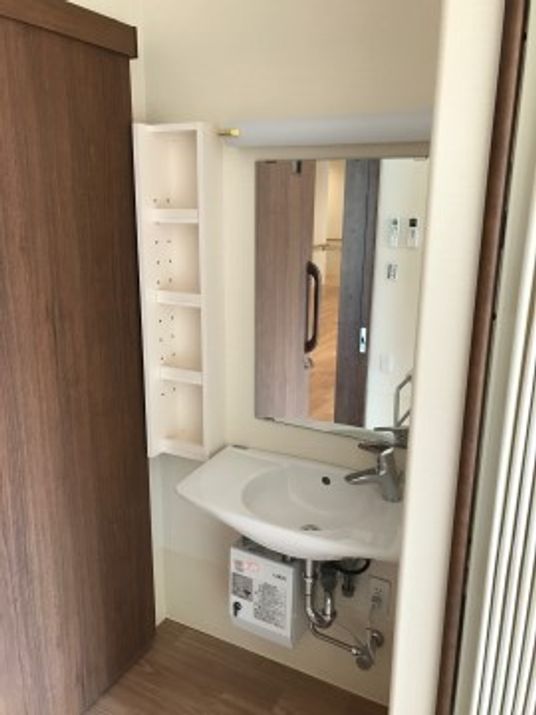 洗面台とシェルフのある居室