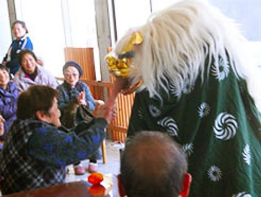 獅子舞と触れ合う高齢者