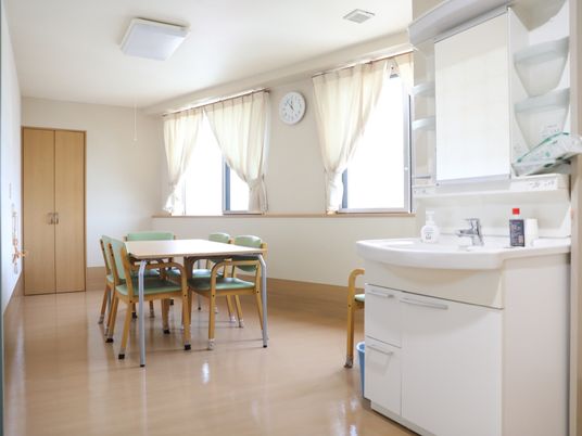 明るい居室のテーブルと洗面台