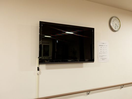 廊下の壁に掛けられたテレビ