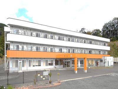 白とオレンジの建物エントランス