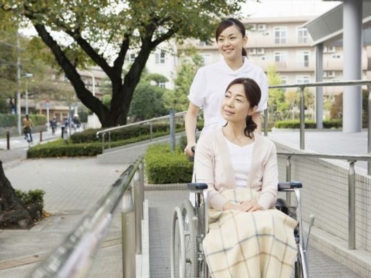 車椅子の女性とスタッフ