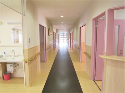 ピンクのドアが並ぶ廊下