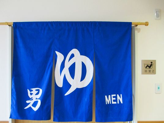 青い暖簾の浴室入口