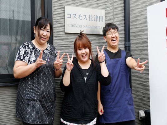 笑顔のスタッフと看板