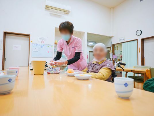 食事支援するスタッフと利用者