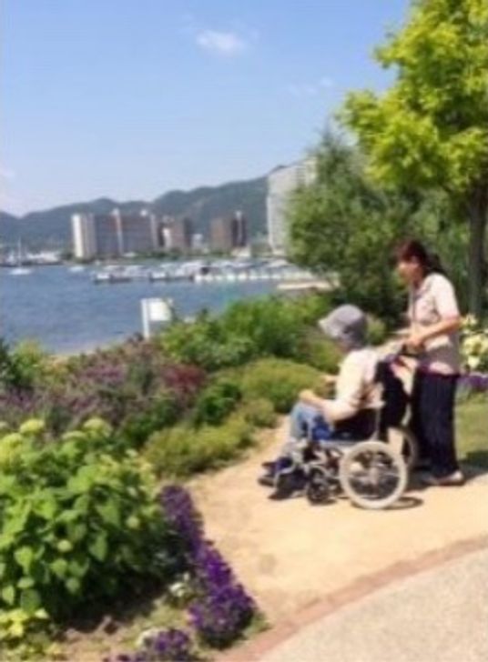車椅子の利用者とスタッフ中庭