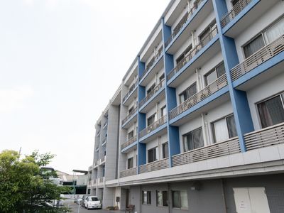 青いアクセントのある居室外観