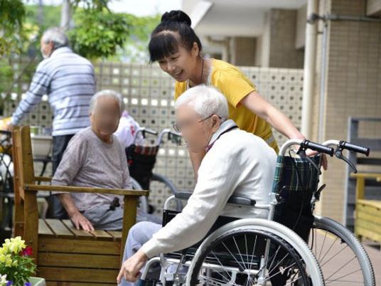 車椅子の高齢者とスタッフ