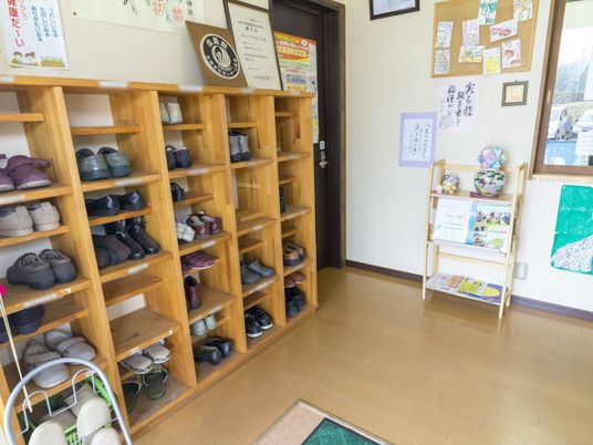 整理された靴と掲示物のエントランス