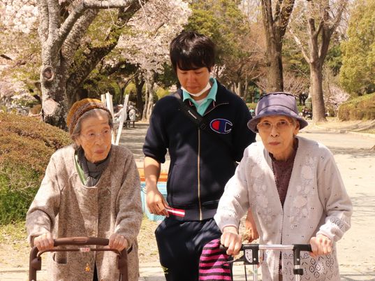 桜の下で散歩する人々