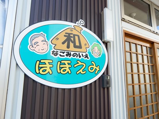 笑顔の看板とドア