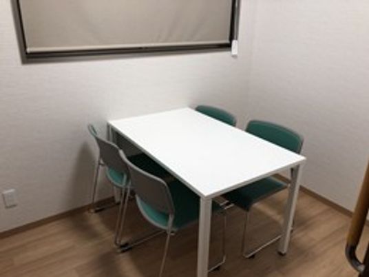 四人用のテーブル椅子付き居室