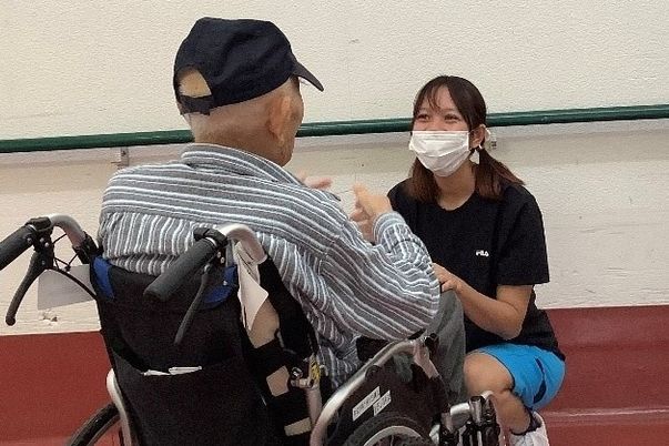 車椅子の方と話すスタッフ
