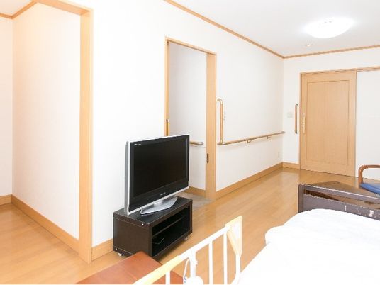 居室のテレビとベッド