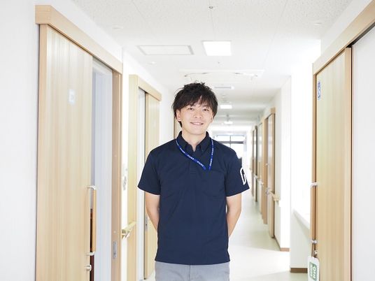 廊下に立つ笑顔のスタッフ