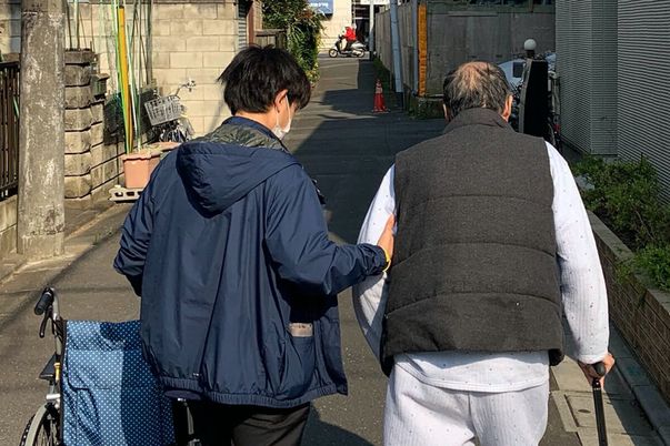 スタッフと散歩する利用者の外観  