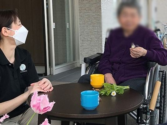 車椅子の居住者とスタッフ